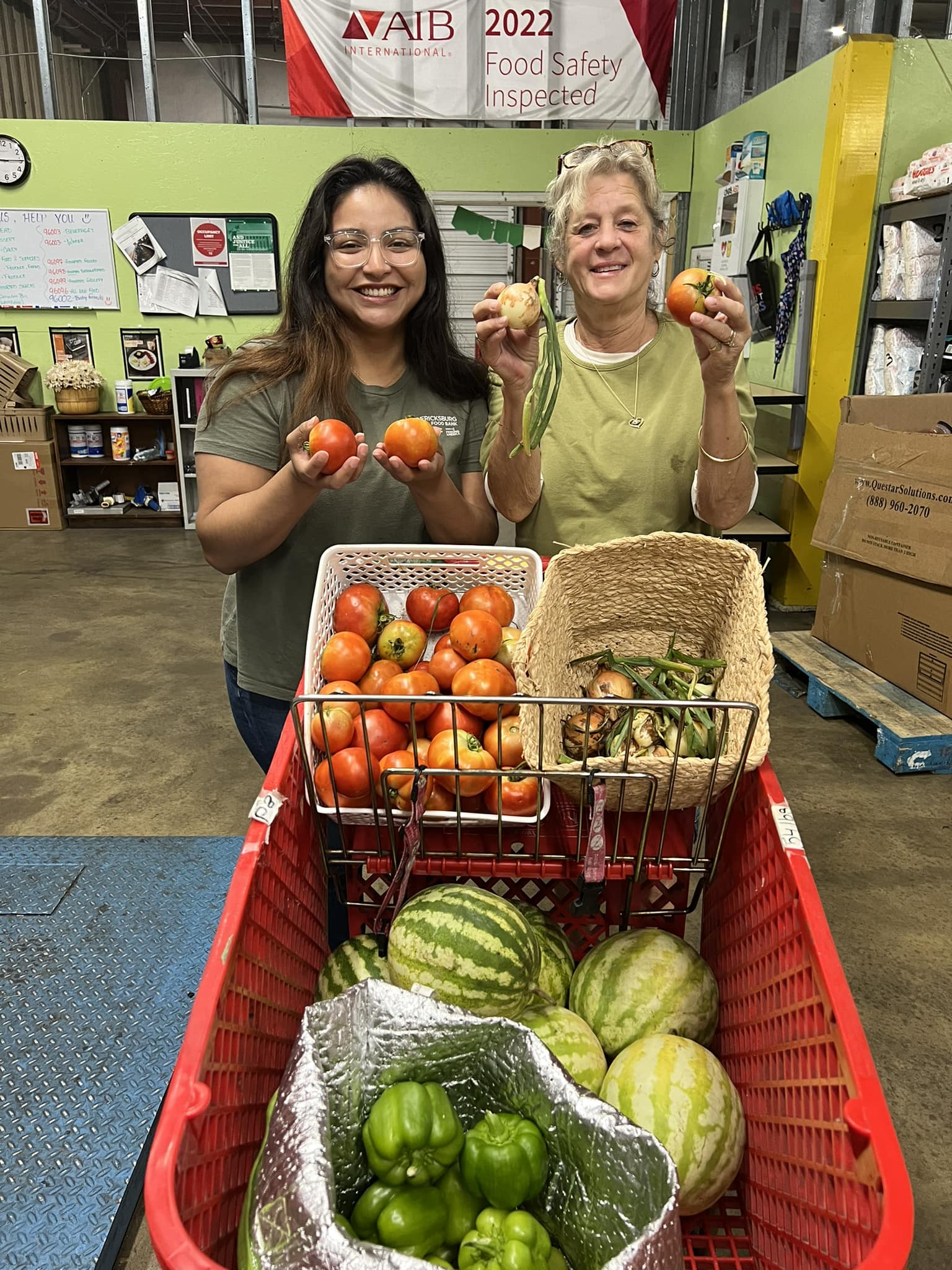 Two women holding produce picked at the REF Food Bank garden